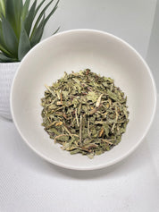 Dried herbs in a white bowl on a light background