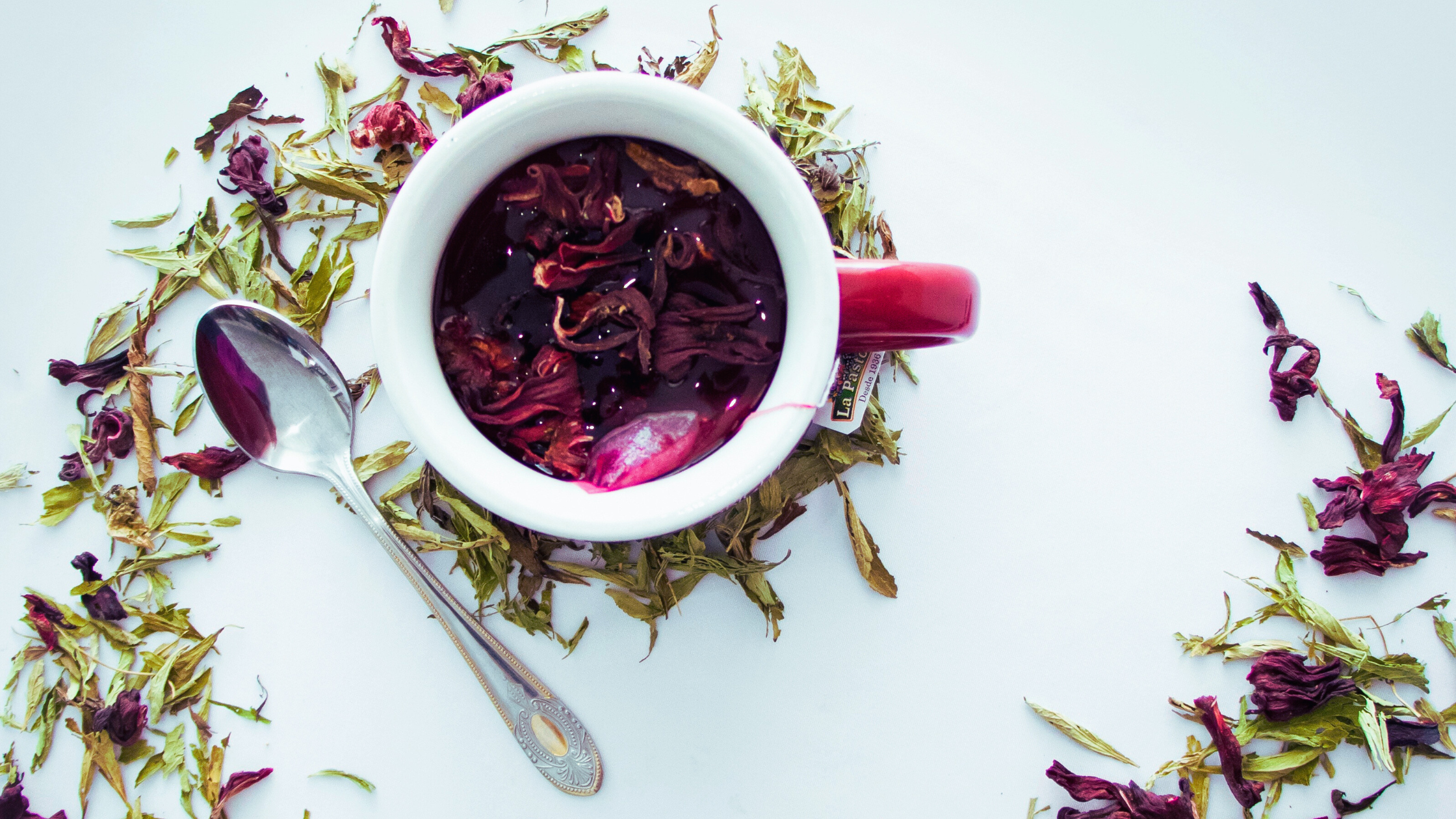 Tea cup with dried herbs and flowers on a white background